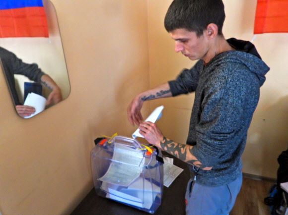 러시아가 점령하고 있는 우크라이나 헤르손주의 한 투표소에서 한 구금자가 러시아 병합 찬반을 묻는 투표에 참여하고 있다. 2022.9.26 타스 연합뉴스