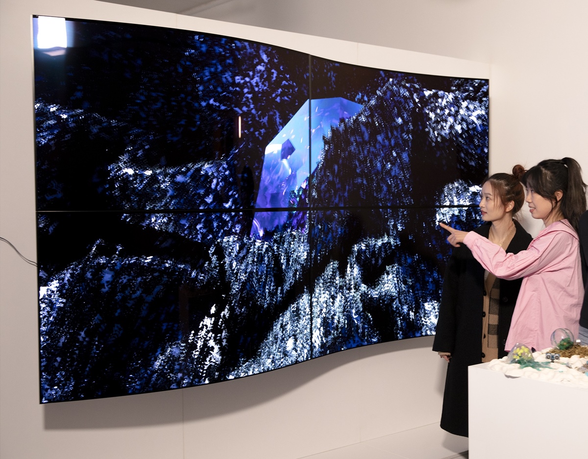 28일(현지시간) 영국 런던에서 열린 디지털아트展 ‘루미너스(Luminous)에서 관람객들이 LG디스플레이의 55인치 커브드 OLED 패널 4대를 상하좌우로 이어붙여 만든 작품명 ‘보이지 않는 혁신(Invisible Reinvention)’을 감상하고 있다. LG디스플레이 제공