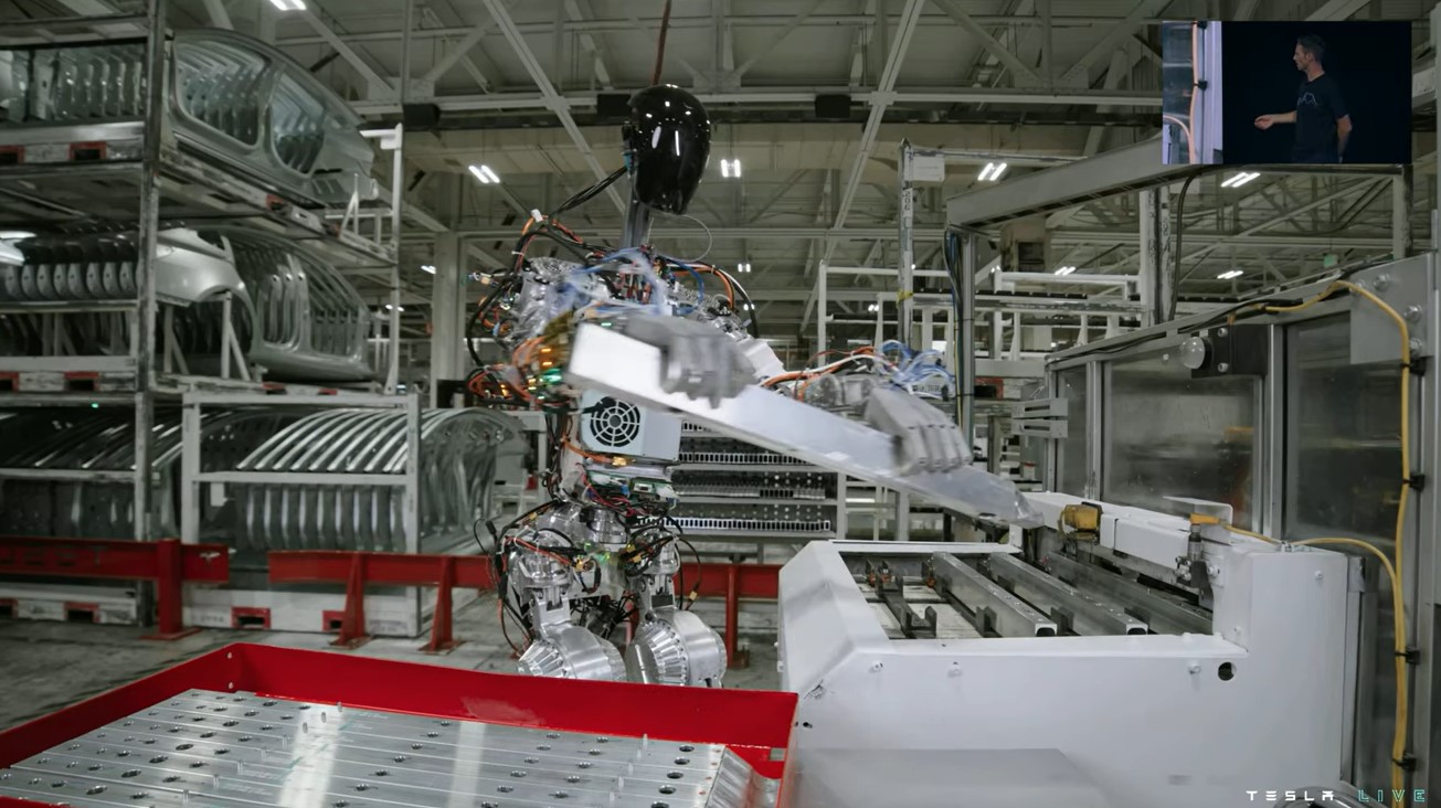 지난 1일(현지시간) 테슬라의 ‘AI데이2’에서 인공지능 로봇 ‘옵티머스’가 공장 작업을 하는 장면이 스크린에 표출되고 있다.  테슬라 실시간 중계 화면 캡처