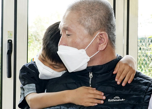 다시 만난 할아버지와 포옹하는 손자