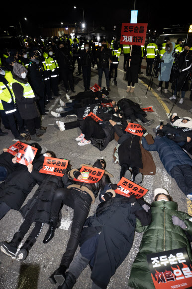 아동 성범죄자 조두순이 출소한 2020년 12월 구로구 서울남부교도소 앞에서 조두순의 출소를 반대하는 집회 참가자들이 바닥에 누워 구호를 외치고 있다. 연합뉴사