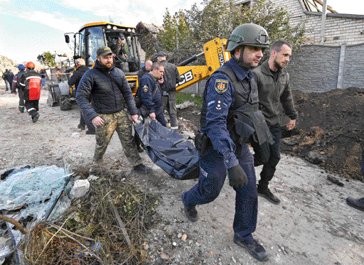9일(현지시간) 러시아가 크림대교 폭발 몇 시간 후 미사일로 보복 공격한 우크라이나 자포리자 주거지역에서 구조대원들과 자원봉사자들이 민간인 시신이 담긴 가방을 옮기고 있다. 자포리자 로이터 연합뉴스