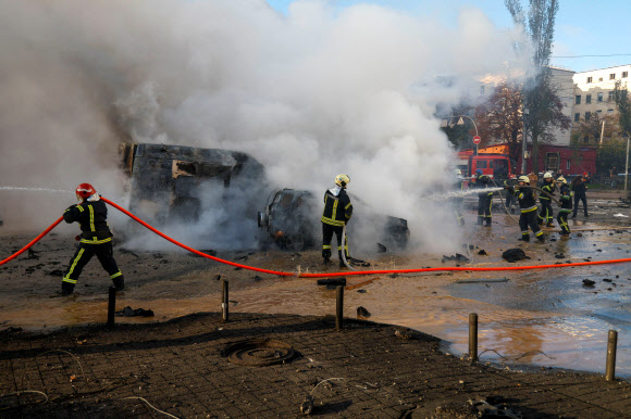 우크라이나 수도 키이우에서 러시아의 미사일 공습으로 인한 여러 차례 폭발이 일어난 가운데 소방관들이 차량 등에 붙은 불을 끄고 있다. 2022.10.10 로이터 연합뉴스