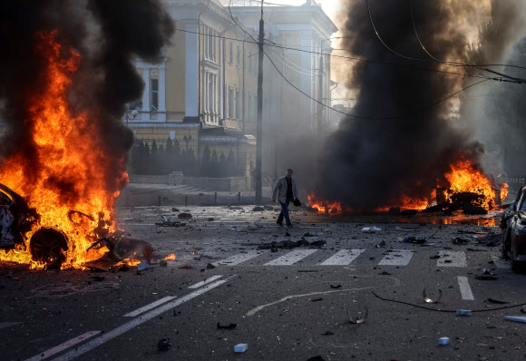10일(현지시간) 우크라이나 수도 키이우에서 미사일 공습을 당한 차량들이 불타고 있다.  로이터 연합뉴스