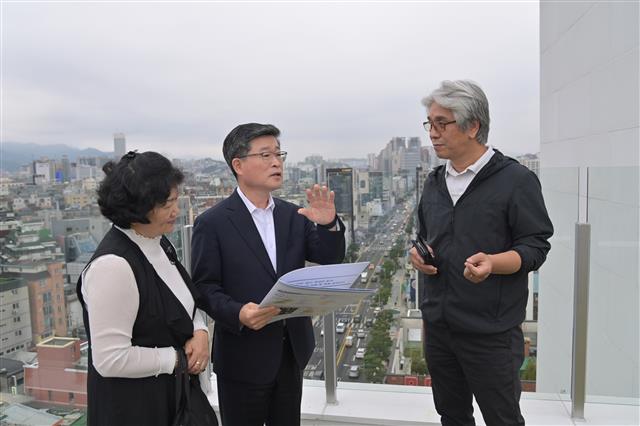 김길성(가운데) 서울 중구청장이 지난 4일 서울 다산로에 위치한 건물 옥상에서 중구 토박이 구민인 오진숙(왼쪽)·오광섭씨에게 다산로 개발 계획에 대해 설명하고 있다.<br>중구 제공