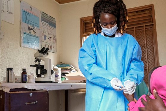 지난달 28일 우간다 무벤데 인근 마두두 지역의 한 클리닉에서 아기에게서 혈액 샘플을 채취하고 있다. AP 연합뉴스