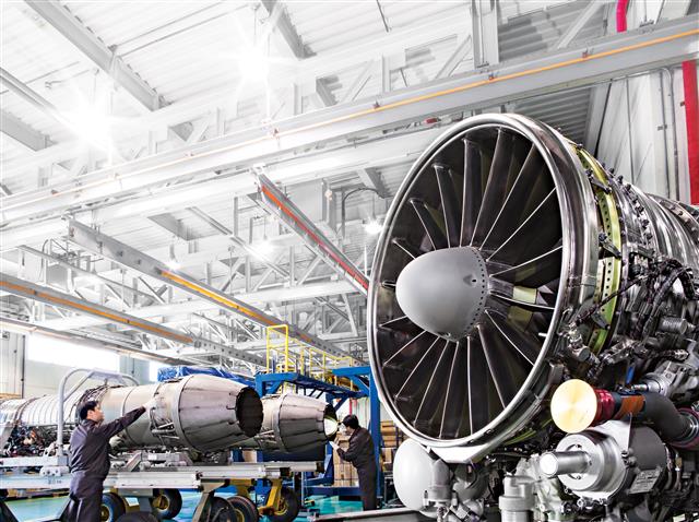 한화에어로스페이스 창원사업장에서 직원들이 제작된 항공기 엔진을 살펴보고 있다. 한화에어로스페이스 제공