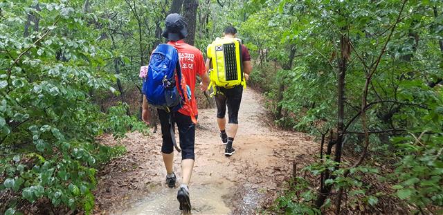 도봉산산악구조대원들이 조난당한 등산객을 구조하기 위해 폭우를 뚫고 산길을 걷고 있다.