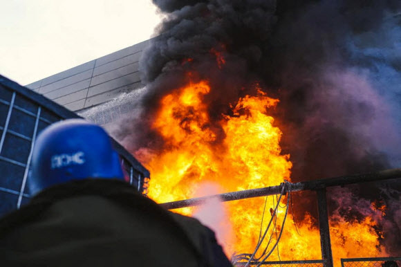 18일(현지시간)러시아군의 공습으로 우크라이나 수도 키이우 발전소에 화재가 발생해 소방관이 불을 끄고 있다.키이우 로이터 연합뉴스