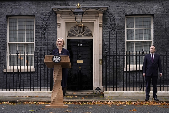 20일(현지시간) 리즈 트러스 영국 총리가 런던 다우닝가 10번지 외곽 총리실 앞에서 남편 휴 오리어리가 지켜보는 가운데 사임을 발표하고 있다. 2022.10.20  AP 연합뉴스
