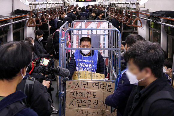 전국장애인차별철폐연대(전장연) 회원들이 25일 오전 서울 용산구 삼각지역에서 장애인권리예산 등을 촉구하는 ‘제41차 출근길 지하철 탑니다’ 시위를 하고 있다. 뉴시스
