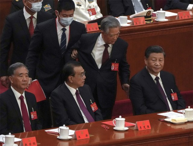 22일 중국 베이징 인민대회당에서 열린 제20차 공산당 전국대표대회(당대회) 폐막식 도중 시진핑 중국 국가주석의 전임자인 후진타오 전 주석이 수행원으로 보이는 남성의 부축을 받고 나가다 시 주석의 등에 손을 대며 말을 걸고 있다. 베이징 AP 뉴시스