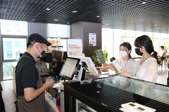DL이앤씨 직원들이 서울 종로구 돈의문 디타워 D라운지카페에서 개인 컵을 사용해 음료를 주문하고 있다. DL이앤씨 제공