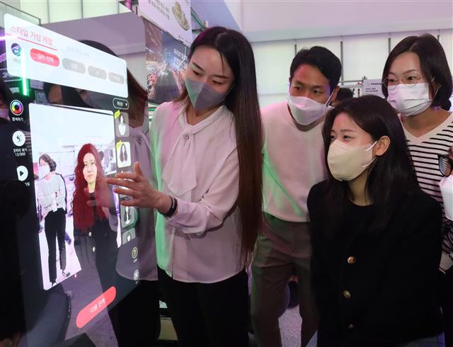 LG그룹이 이달 중순 개최한 ‘슈퍼스타트 데이 2022’ 현장에서 관람객들이 가상현실(VR) 스마트 미러를 직접 체험하고 있는 모습. LG 제공