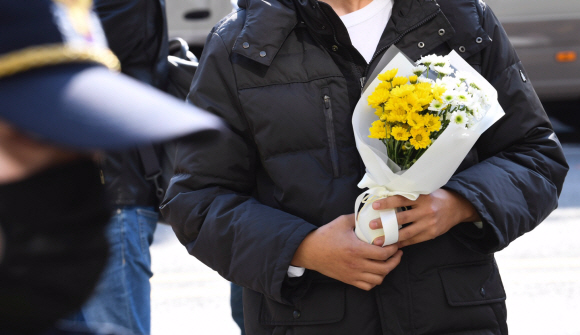 30일 오후 서울 용산구 이태원 압사 사고 현장 인근에 한 시민이 희생자를 추모하기 위해 꽃을 들고 있다. 2022.10.30. 오장환 기자