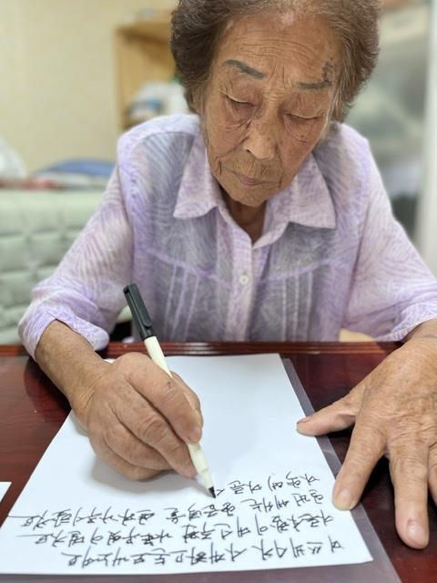 일제 강제동원 피해자인 양금덕 할머니가 “일본에서 사죄를 받기 전에는 죽어도 죽지 못하겠다”는 내용의 편지를 손으로 쓰고 있다. 일제강제동원시민모임 제공