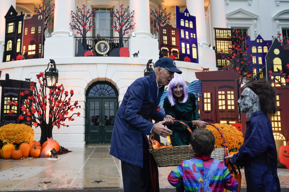 조 바이든 대통령과 질 바이든 영부인은 2022년 10월 31일 월요일 워싱턴에서 백악관 사우스 론에서 ‘트릭 오어 트릿’(trick-or-treat) 사탕을 사람들에게 나눠주고 있다.. (AP)