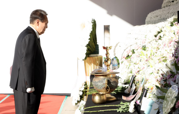 윤석열 대통령이 2일 오전 서울광장에 마련된 이태원 사고 사망자 합동분향소를 방문, 헌화한 뒤 희생자 사진을 보고 있다. 2022.11.2  연합뉴스