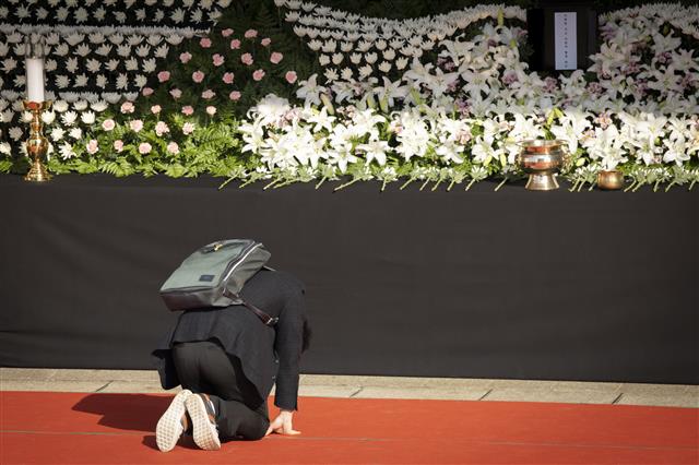 한 학생이 지난달 31일 서울시청에 마련된 ‘이태원 핼러윈 참사’ 추모를 위한 합동 분향소를 찾아 헌화를 마친뒤 무릎을 꿇고 있다. 뉴스1