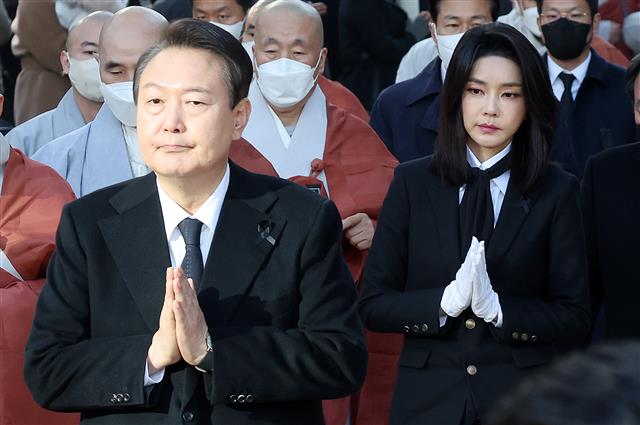 합장한 채 이동하는 윤석열 대통령 내외