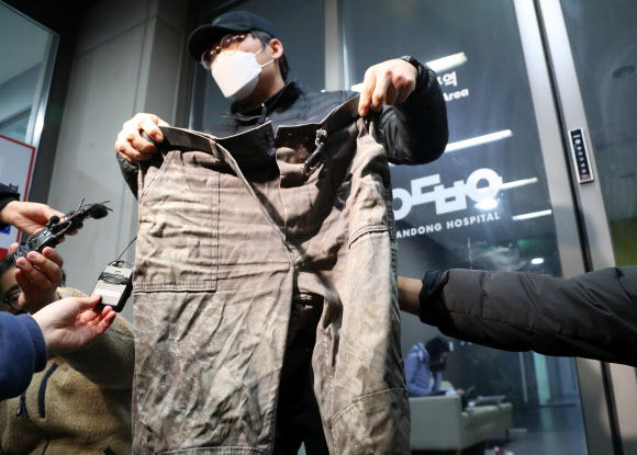 5일 경북 안동병원 응급실 앞에서 봉화군 아연광산 매몰사고로 고립됐다가 구조된 작업반장 박모(62)씨의 아들 박근형(42)씨가 고립 당시 박씨가 입고 있던 작업복을 취재진에게 보여주고 있다. 2022.11.5  연합뉴스