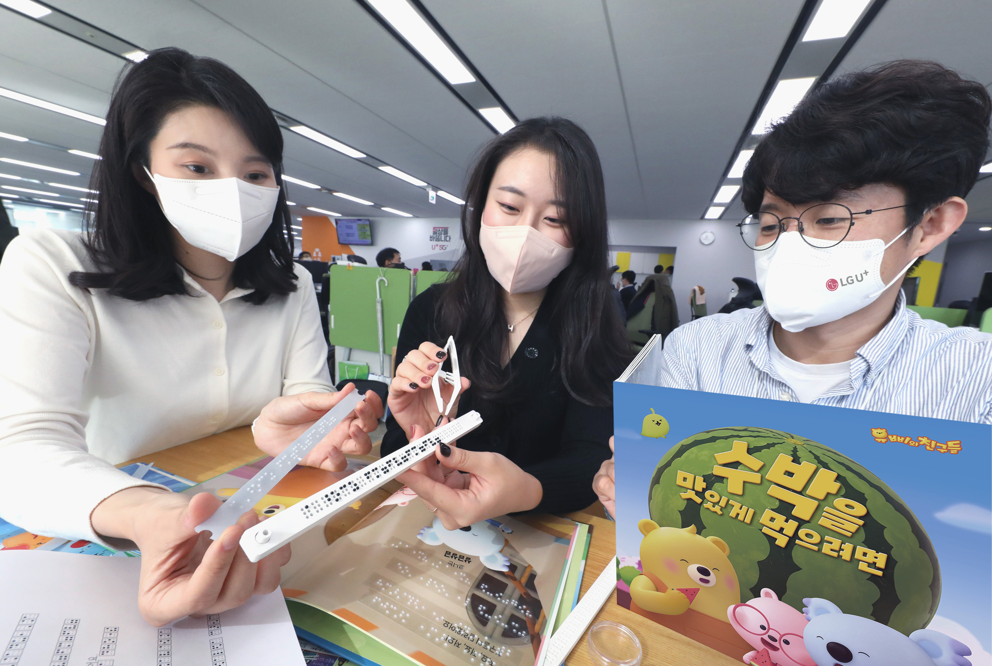 LG유플러스 임직원들이 사회공헌 활동으로 전국 도서관에 기부할 점자 동화책을 제작하고 있다. LG유플러스 제공