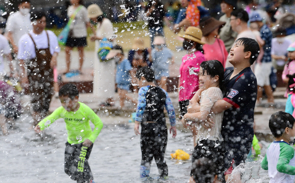서울 낮 기온이 31도까지 오르며 무더운 날씨를 보인 12일 오후 서울 여의도 물빛광장에서 시민들이 물놀이를 하며 더위를 식히고 있다. 2022.06.12 정연호 기자