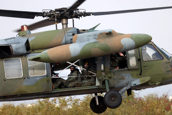 8일 오후 경기 하남시 특전사 고공훈련장에서 열린 제44회 특수전사령관배 고공강하 경연대회에서 헬기에 탑승한 참가자들이 손인사를 하고 있다. 2022.11.8 연합뉴스