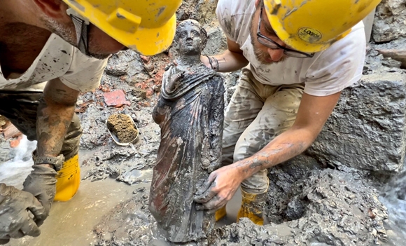 이탈리아 토스카나주 시에나 산 카시아 노 데이 바니의 온천 유적지에서 발굴대가 진흙 속에서 나온 2300년 전 청동상을 들고 있다. 2022.11.8  로이터 연합뉴스