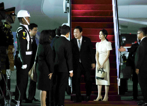 윤석열 대통령과 김건희 여사가 주요 20개국(G20) 정상회의 참석을 위해 13일(현지시간) 인도네시아 발리 응우라 라이 국제공항에 도착, 인사하고 있다. 2022.11.14  연합뉴스