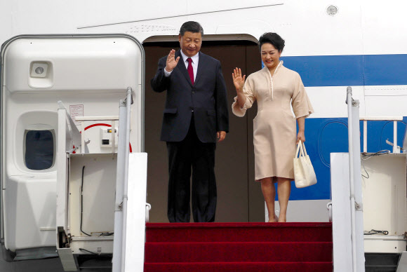 Chinese President Xi Jinping (L) and his wife Peng Liyuan disembark from their plane as they arrive at Ngurah Rai International Airport ahead of the G20 Summit in Bali, Indonesia, 14 November 2022. The 17th Group of Twenty (G20) Heads of State and Government Summit will be held in Bali from 15 to 16 November 2022.  EPA 연합뉴스