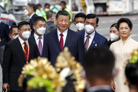 Chinese President Xi Jinping, center, walks with his wive Peng Liyuan, right, upon arrival at Ngurah Rai International Airport ahead of the G20 Summit in Bali, Indonesia, Monday, Nov. 14, 2022. AP 연합뉴스