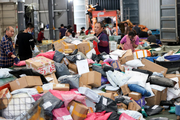 중국 최대 쇼핑축제 솽스이(광군제)가 열린 지난 11일 장쑤성 롄윈강의 한 온라인 쇼핑몰 물류센터에서 직원들이 솽스이 주문 제품을 분류하고 있다. 롄윈강 AFP 연합뉴스