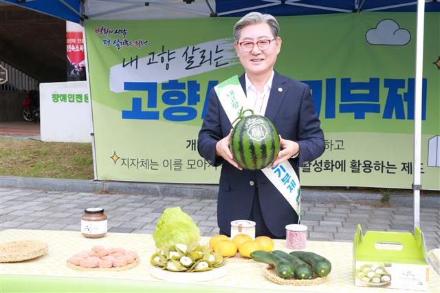 전국 243개 지방자치단체가 내년 시행될 고향사랑기부제 준비에 여념이 없다. 기존 귀농·귀촌 정책이 도시민의 물리적인 이주 정책을 의미했다면 고향사랑기부제는 도시민과 지역 간 기부를 통해 소통하는 ‘관계인구’를 형성시킬 정책으로 평가받는다. 오태완 경남 의령군수가 지난 9월 고향사랑기부금의 답례품으로 검토하는 특산물 가운데 하나인 수박을 들어 보이고 있다.  서울신문 DB