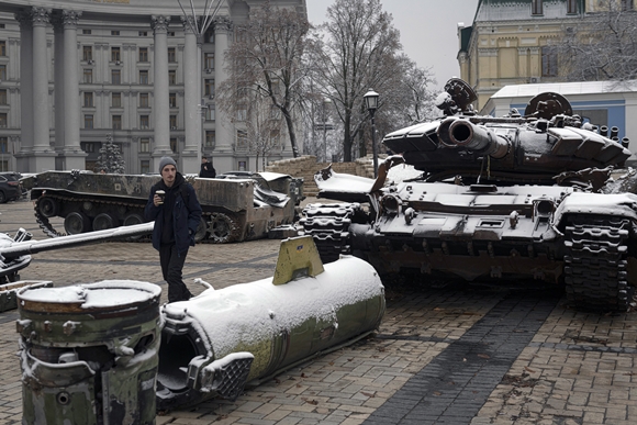 17일(현지시간) 첫눈이 내린 우크라이나 수도 키이우 시내에서 한 주민이 파괴된 러시아군 탱크와 장갑차 앞을 지나고 있다. 2022.11.17  AP 연합뉴스