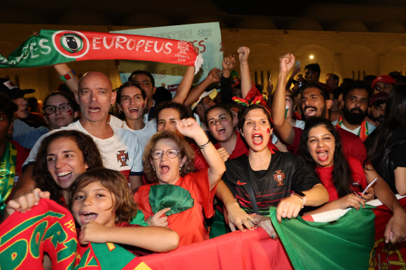 19일(현지시간) 카타르 도하의 포르투갈 대표팀 숙소 앞에서 팬들이 대표팀을 기다리며 노래를 부르고 있다. 도하 연합뉴스