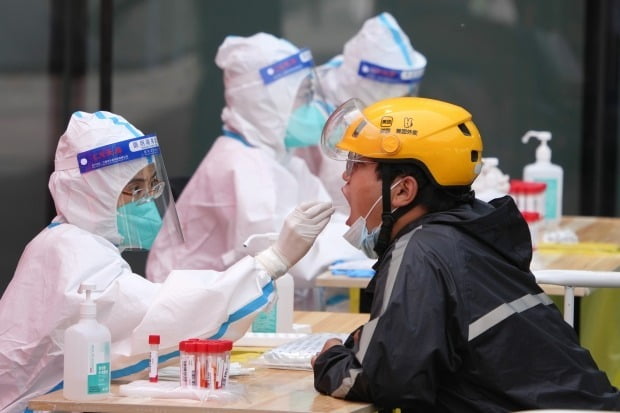 중국 수도 베이징 차오양구에서 한 의료인이 코로나19 검사를 위해 주민에게서 검체를 채취하고 있다. 연합뉴스