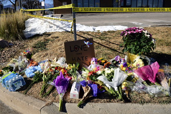 미국 시민들이 20일(현지시간) 콜로라도주 콜로라도 스프링스의 나이트클럽 클럽Q 인근에 총기난사 희생자들을 추모하기 위해 꽃을 가져다 놓았다. AP