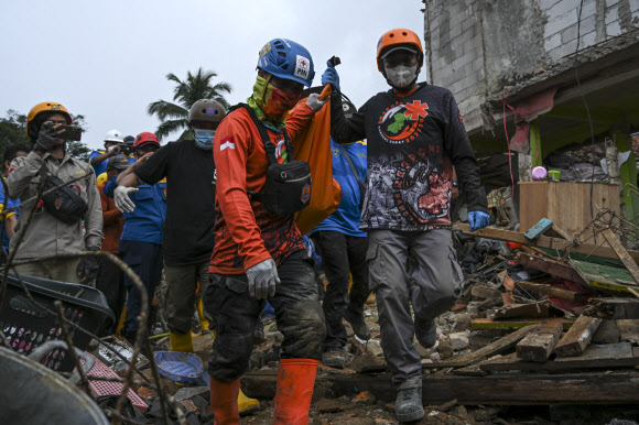 인도네시아 서부자바주(州) 찌안주르 지역에서 구조대원들이 지진으로 사망자의 시신을 옮기고 있다. 지난 21일(현지시간) 이 지역에서 발생한 규모 5.6의 지진으로 270여명이 사망했다. 2022.11.23 신화 연합뉴스