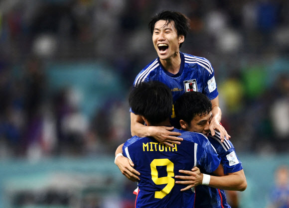 일본 축구대표팀의 카오루 미토마, 와타루 엔도, 유토 노가토모가 23일 카타르 도하의 칼리파 스타디움에서 열린 독일전에서 승리한 후 기뻐하고 있다. 로이터 도하 연합뉴스