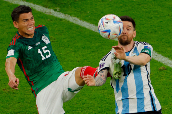 멕시코의 수비수 15번 헥터 모레노(L)가 2022년 11월 26일 도하 북쪽 루사일의 루사일 스타디움에서 열린 카타르 2022 월드컵 C조 조별리그 아르헨티나와 멕시코의 경기에서 아르헨티나의 공격수 10번 리오넬 메시(R)와 공을 다투고 있다( AFP).