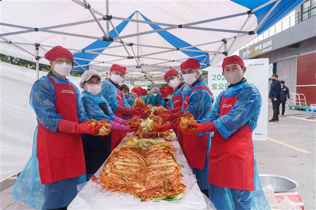 다케무라 노부유키(왼쪽 세 번째) 한국토요타자동차 사장 등 회사 관계자와 자원봉사자들이 최근 열린 ‘토요타·렉서스 제주 딜러 사랑의 김장나눔’ 행사에서 담근 김치를 소개하고 있다. 한국토요타자동차 제공