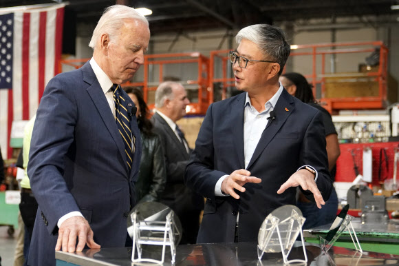 조 바이든 미국 대통령(왼쪽)이 미시간주 SK실트론 공장에서 웨이퍼에 대한 설명을 듣고 있다. AP