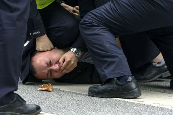 지난 27일 중국 상하이에서 경찰이 제로 코로나 정책에 항의하는 ‘백지 시위’ 참가자를 체포하고 있다. 상하이 AP 연합뉴스