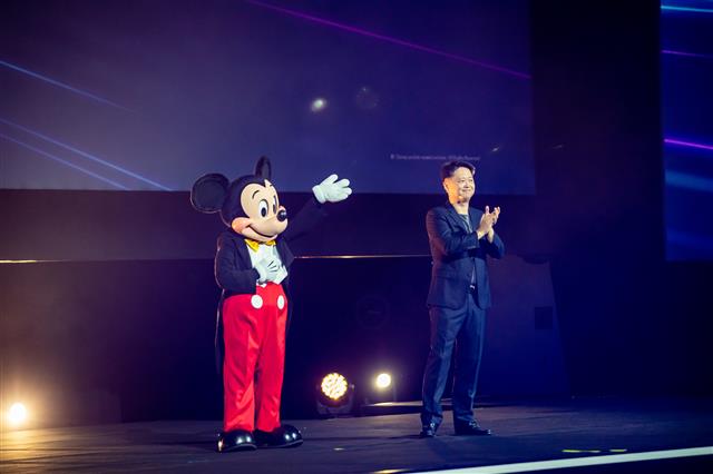 디즈니의 마스코트인 미키 마우스가 30일 싱가포르에서 열린 ‘디즈니 쇼케이스 2022’에서 루크 강 월트디즈니 컴퍼니 아태지역 총괄 사장의 소개로 등장해 관객들에게 인사하고 있다. 월트디즈니 제공