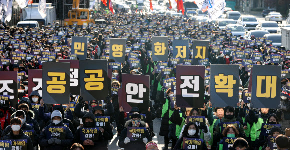 민주노총 공공운수노조 조합원들이 1일 서울 용산구 대통령 집무실 인근에서 열린 공동파업-총력투쟁 결의대회에서 팻말을 들고 있다. 연합뉴스