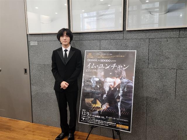 피아니스트 임윤찬이 일본 첫 공연을 하루 앞둔 지난 2일 도쿄 주일 한국문화원의 공연 포스터 옆에서 포즈를 취하고 있다.