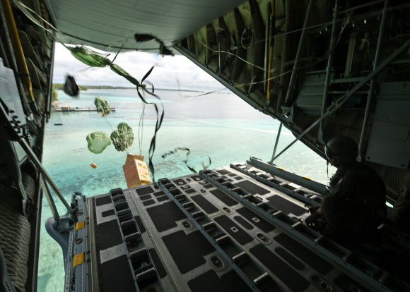 공군이 지난 4일부터 9일까지 진행되는 크리스마스 공수작전 본 훈련에서 마이크로네시아(Micronesia) 지역 10여 개 섬에 의약품, 의류, 생활필수품 등의 물품을 공수한다고 5일 밝혔다. 사진은 미국 괌 앤더슨 공군기지에서 크리스마스 공수작전에 참가한 공군 제15특수임무비행단 소속 작전요원들이 마이크로네시아 지역 주민들에게 전달할 화물을 공중투하하는 모습. 2022.12.5  공군 제공