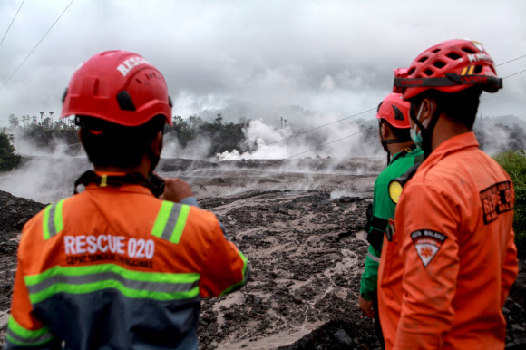 (221204) -- LUMAJANG, Dec. 4, 2022 (Xinhua) -- Rescuers inspect the affected area after the eruption of Mount Semeru at Sapiturang village in Lumajang, East Java, Indonesia, Dec. 4, 2022. Semeru volcano on Indonesia‘s Java island erupted on Sunday, spewing a 1.5-km high ash column, authorities said.    As of Sunday afternoon, the country’s Volcano Disaster Mitigation of the Center for Volcanology and Geological Hazard Mitigation (PVMBG) has raised its volcanic alert level for Semeru volcano to level 4, the highest level of a four-tier volcanic alert system. (Photo by Bayu Novanta/Xinhua)