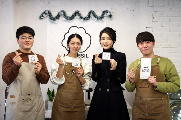 김건희 여사가 8일 부산 금정구 몽실커피를 방문해 자립준비청년 창업자들과 대화한 뒤 기념촬영을 하고 있다. 이 카페는 아동양육 시설에서 성장한 청년들이 창업한 곳으로, 이 청년들은 다른 자립준비청년들을 돕고 있다.  2022.12.8  대통령실 제공
